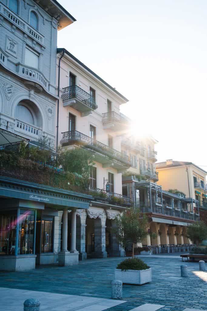 Some of the pastel colored buildings on Bellagio's lakefront lit from behind at sunrise