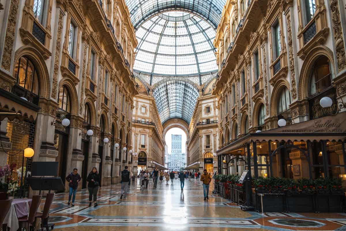 The Galleria Vittorio Emanuele in Milan at sunrise with few people, a quiet and safe moment in the bustling city.