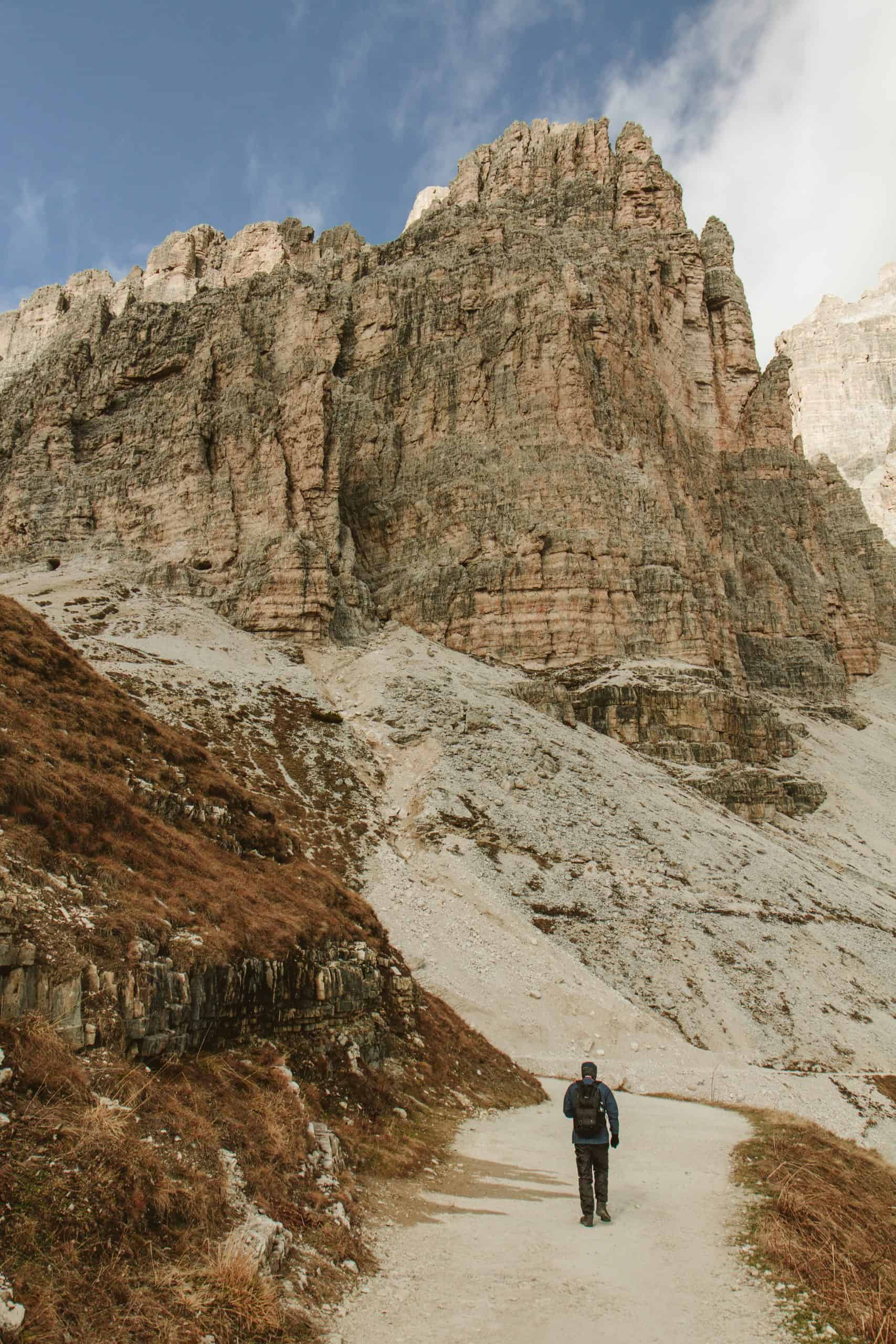 A man wallking on the trail of Tre Cime di lavaredo in autumn