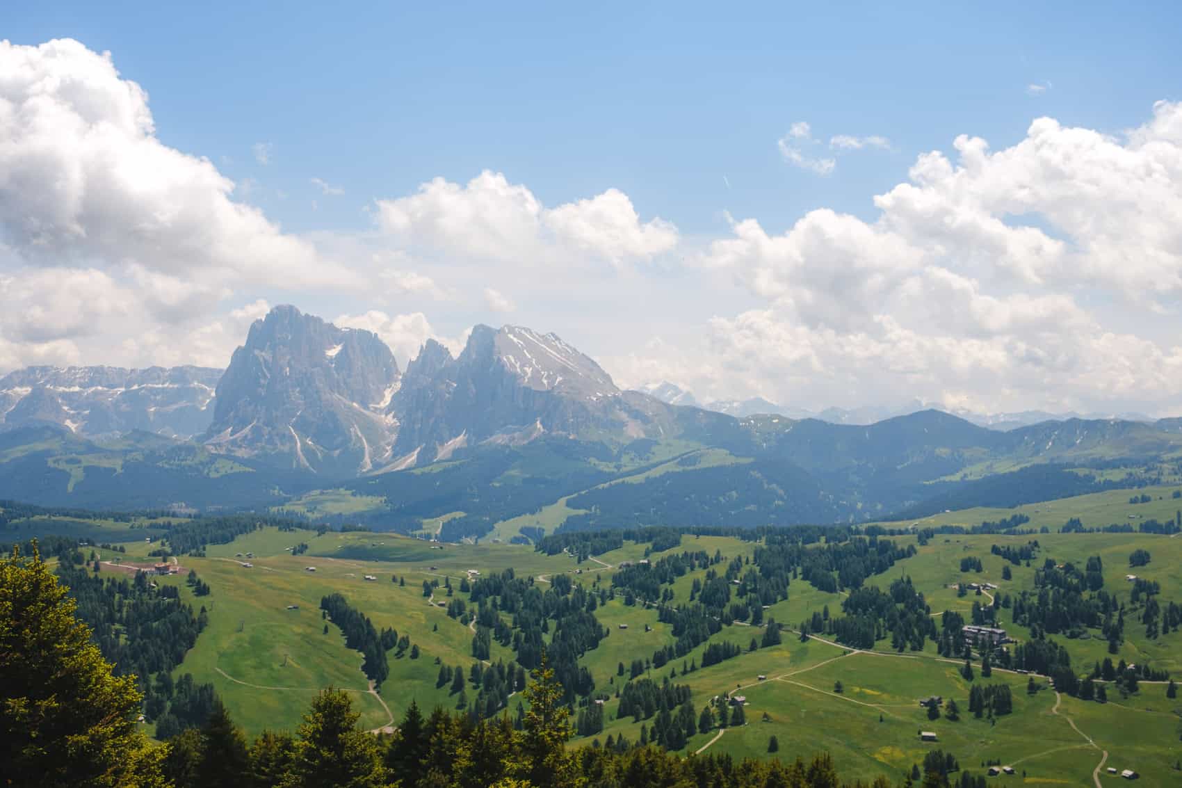 A view of the Dolomites from Alpe di Siusi with mountain peaks and fields